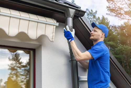 A local gutter installer working on a new gutter for a house in Bucks County PA